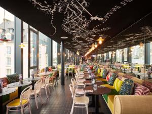 a restaurant with tables and chairs and windows at Mama Shelter Rennes in Rennes
