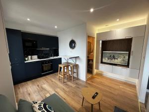 a living room with a kitchen with blue cabinets at Casa Mediterraneo - Vue mer 3 min de la plage à pieds in Cap d'Ail