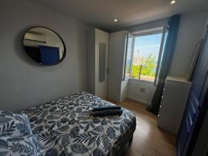 a bedroom with a bed and a mirror on the wall at Casa Mediterraneo - Vue mer 3 min de la plage à pieds in Cap d'Ail