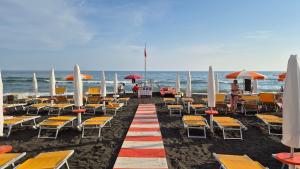 a beach with chairs and umbrellas and the ocean at Ladispoli Apartment in Ladispoli