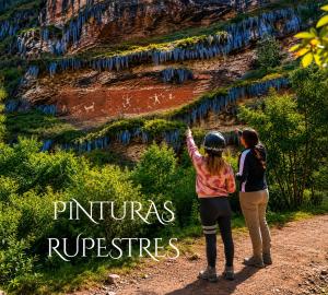 two women standing on a dirt road looking up at a mountain at Chaska Valle Green in Urubamba