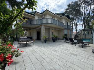 a house with a patio with chairs and a balcony at RestCoast Villa in Shekhvetili