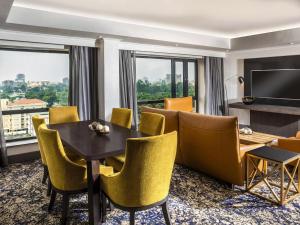a hotel room with a dining table and chairs at Mövenpick Hotel Ikoyi Lagos in Lagos