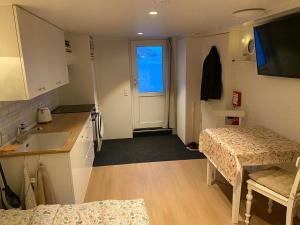 a small room with a kitchen with a table and a sink at Elf's Cottage in Vatnsoyrar +5 photos