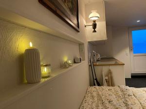 a room with a candle on the wall next to a bed at Elf's Cottage in Vatnsoyrar