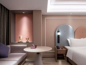 a hotel room with a bed and a table at Mercure Chengdu Wuhou Temple in Chengdu