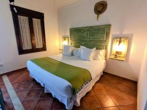 a bedroom with a large bed with a green headboard at "La Güena Vida" Chalet con 4 Habitaciones de Hotel in Algodonales +44 photos