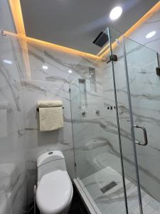 a bathroom with a toilet and a glass shower at Loft Rome Nacosari in Aguascalientes