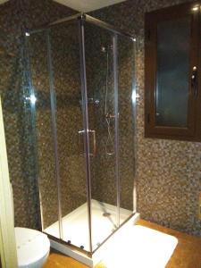 y baño con ducha y aseo. en Apartamentos Turísticos La Garza, en Cáceres