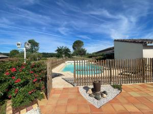 a fence around a swimming pool in a yard at Grande maison avec piscine chauffée privée en Quercy in Lacour