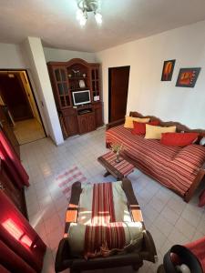 a living room with a couch and a tv at Cabañas Las Lomas in Juana Koslay 