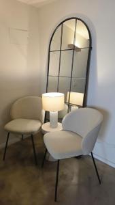 a room with a chair and a lamp and a mirror at La Pietra - Bari Vecchia, Vista Mare in Bari