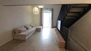 a living room with a couch and a staircase at La Pietra - Bari Vecchia, Vista Mare in Bari