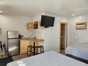 ein kleines Zimmer mit Küche und Kühlschrank in der Unterkunft Quest Motel in Whitewood