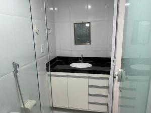 a bathroom with a sink and a glass shower at El Shaday Suítes - ATÍNS in Atins