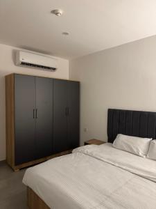 a bedroom with two beds and a large cabinet at Rami Grand Residence in Erbil