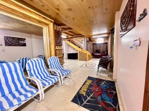 a living room with chairs and a staircase at The Valley View Pent House in Murree