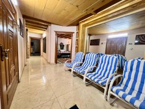 a corridor with blue and white chairs in a room at The Valley View Pent House in Murree