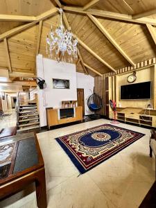 a large living room with a rug on the floor at The Valley View Pent House in Murree