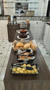 a table in a kitchen with several baskets of food at Hotel Silveira in Guarapari