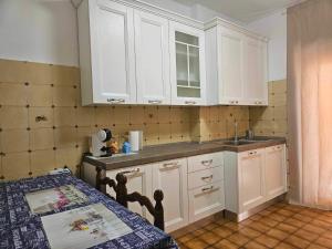 a kitchen with white cabinets and a table and a sink at Nido Urbano Roma in Rome