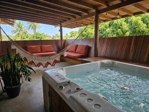 a hammock and a hot tub on a patio at HaraMatha in Barra Grande