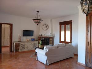 a living room with a white couch and a tv at "La Güena Vida" Chalet con 4 Habitaciones de Hotel in Algodonales