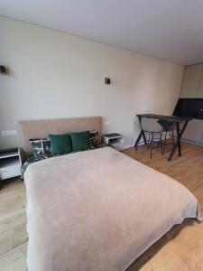 a bedroom with a large white bed with green pillows at Labaresto Plaza jums in Vilnius