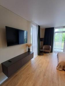 a living room with a flat screen tv on the wall at Labaresto Plaza jums in Vilnius