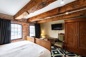 ein Schlafzimmer mit Bett, Schreibtisch und Fernseher in der Unterkunft Hotel Bulwar Ustka in Ustka