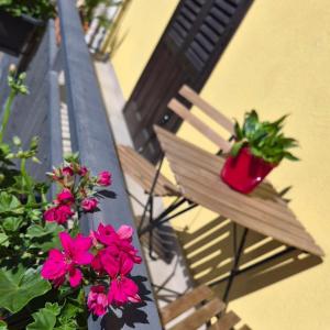 a pair of chairs with flowers on a balcony at Maresia Apartment in Altavilla Milicia