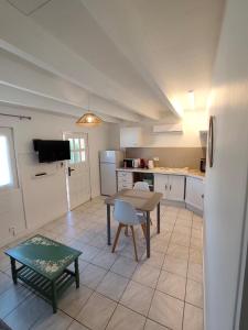 a kitchen with a table and a chair and a table at la crique in Sisco