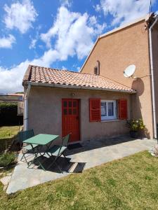 a small house with a green table in front of it at la crique in Sisco