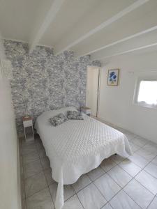 a bedroom with a white bed and a wall at la crique in Sisco