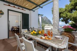 a table with fruit and drinks on a patio at Villa Preziosa - Panoramic Sea View in Capri