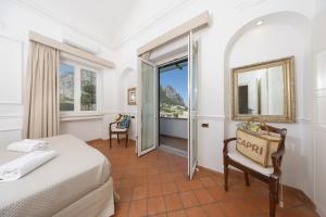 a hotel room with a bed and a window at Villa Preziosa - Panoramic Sea View in Capri