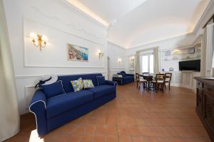 a living room with a blue couch and a table at Villa Preziosa - Panoramic Sea View in Capri