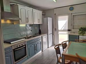 a kitchen with white cabinets and a table with a tableablish at Casa da Avenida in Mértola