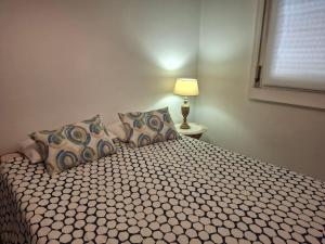 a bedroom with a bed with pillows and a lamp at Casa da Avenida in Mértola +10 photos