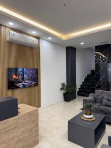 a living room with a couch and a staircase at Rami Grand Residence in Erbil