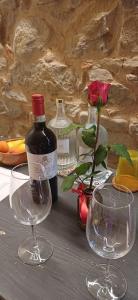 a table with two wine glasses and a bottle of wine at Casa Pulci in Grinzane Cavour