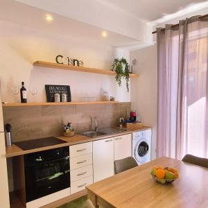 a kitchen with a table and a sink and a dishwasher at Maresia Apartment in Altavilla Milicia