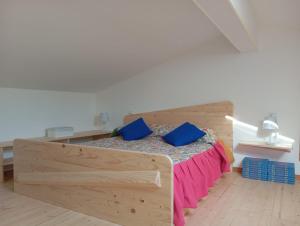 a bedroom with a wooden bed with blue pillows at Ca Lovisotto in Prepotto +70 photos