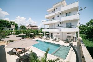a view of a building with a pool and umbrellas at B&B Lovac Pool & Spa in Ulcinj