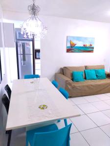 a living room with a table and a couch at Lindo apartamento em Muro Alto, Porto de Galinhas, Vista para as piscinas, 3 qtos e sala climatizados, Acomoda até 8 pessoas in Ipojuca