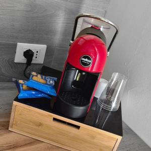 a red blender sitting on top of a wooden stand at Maresia Apartment in Altavilla Milicia