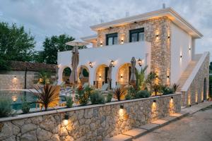 a house with a stone wall and lights at B&B Lovac Pool & Spa in Ulcinj