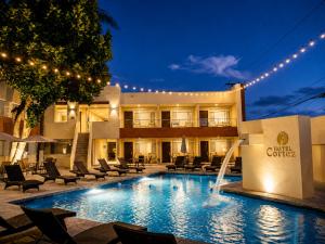 a hotel with a swimming pool in front of a building at Hotel Cortez Baja Inn, Ensenada in Ensenada