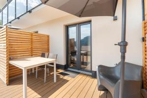 a dining room with a table and an umbrella at Lake Lodge Ossiacher See in Annenheim