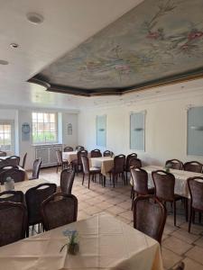 a dining room with tables and chairs and a painting on the wall at Campus Hotel - ehemals Hotel Paseo in Aachen